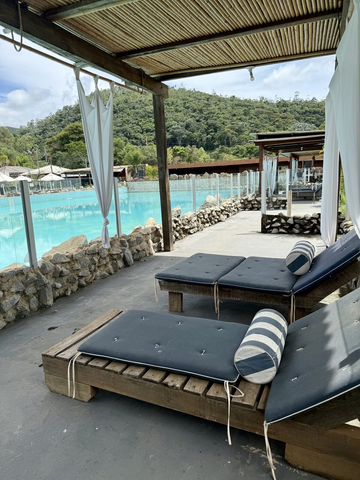 Cabana VIP à beira da piscina, com cortinas e vista para as montanhas