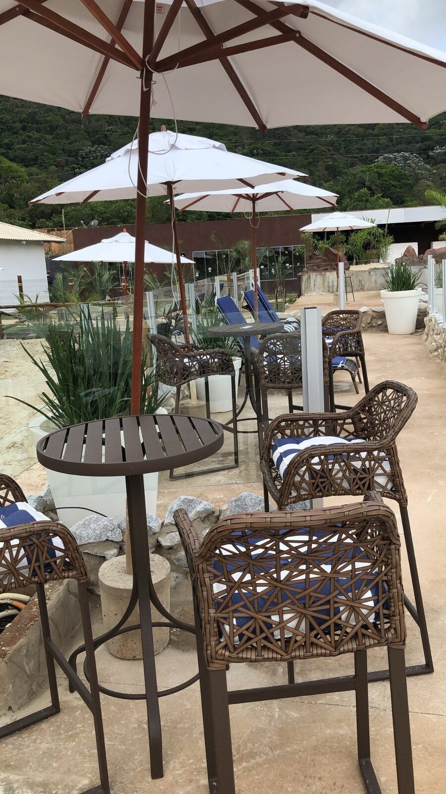 Mesas com guarda-sol na área da cabana